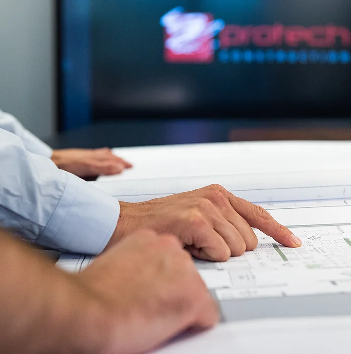 General contractor and interior designer reviewing architect's sketch during a commercial renovation project.